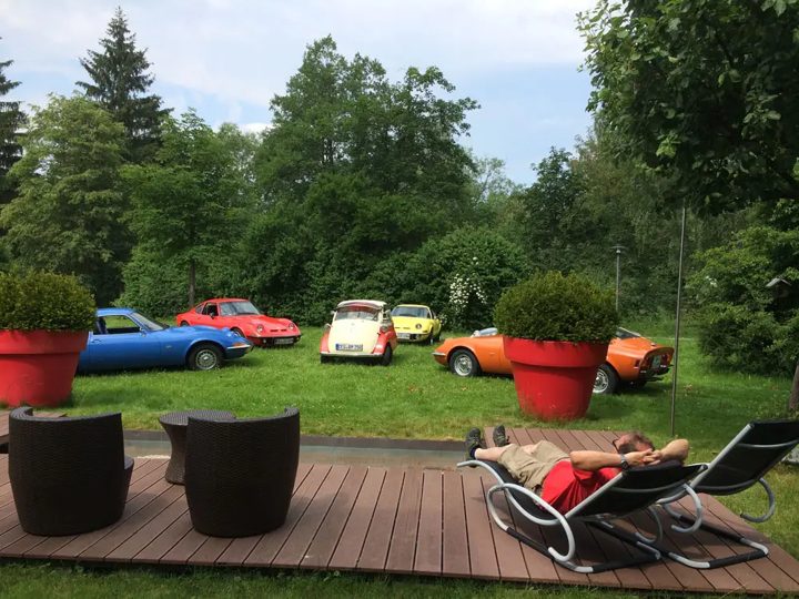 Oldtimer auf der Wiese im Park hinter der Holzterrasse