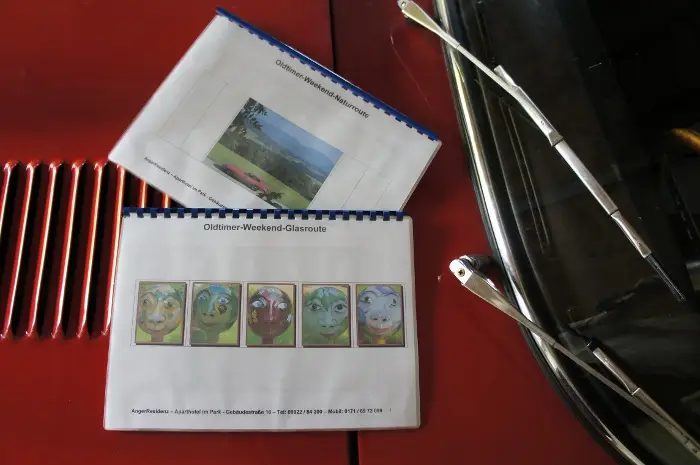 Roadbook-Mappe mit Streckenbildern auf rotem Lack