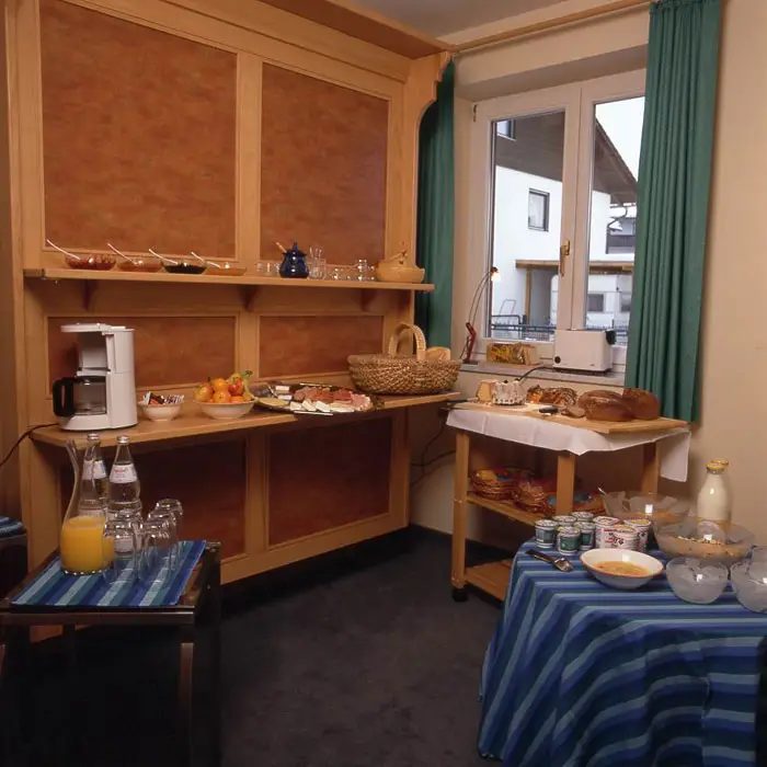 Frühstücksbuffet mit Brot, Säften und Geschirr