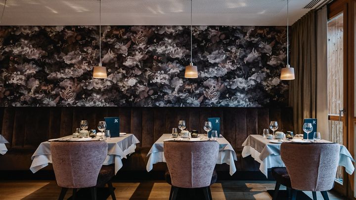 Restaurant mit gedeckten Tischen und Polsterstühlen