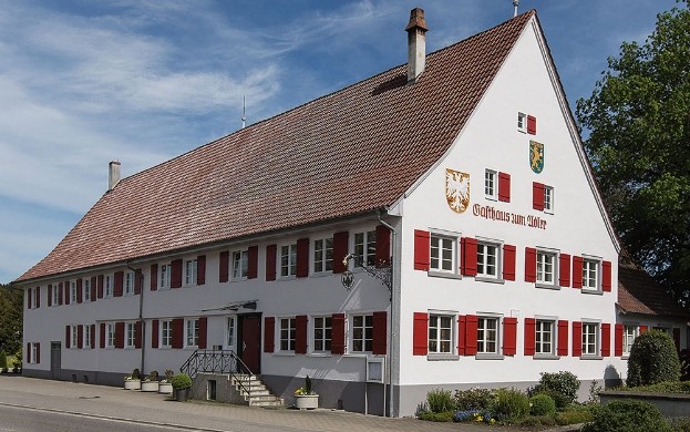 Gasthaus Adler mit roten Fensterläden und Wappen an der Fassade