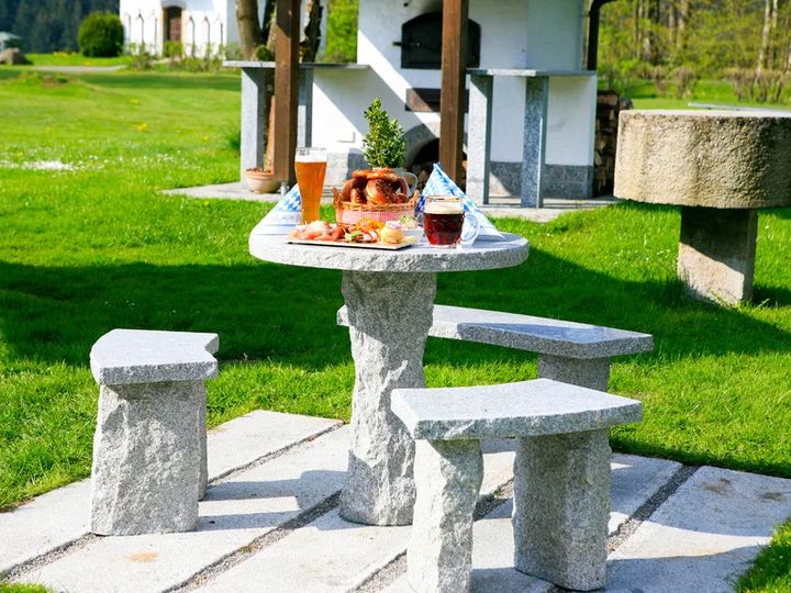 Steintisch mit Brotzeit und Getränken auf einer Wiese