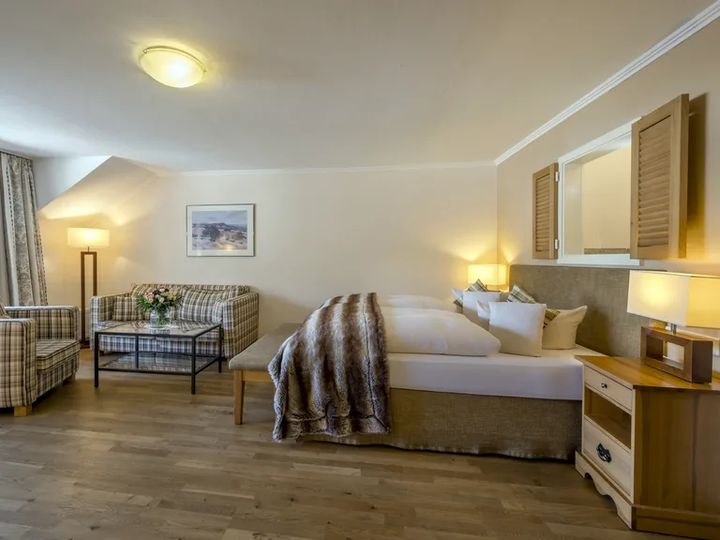 Doppelzimmer mit Fellplaid auf dem Bett und Sitzecke