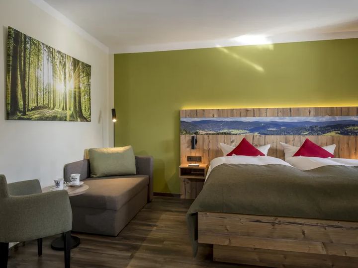 Doppelzimmer mit Waldbild, Sessel und Doppelbett