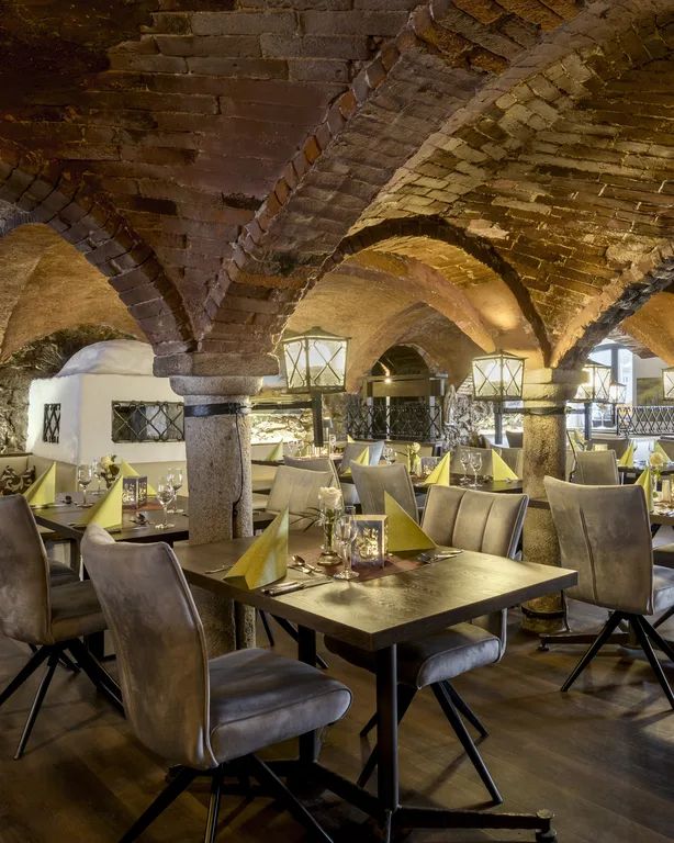 Restaurant mit gedeckten Tischen unter Backsteingewölbe