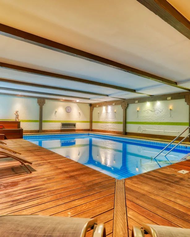 Hallenbad mit Holzliegen am Beckenrand