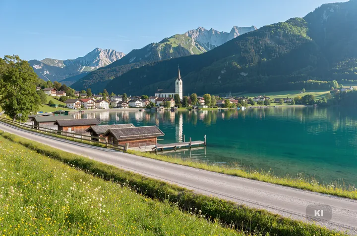 KI-Symbolbild: See im Salzkammergut mit Bergen, Dorf mit Kirche und Bootshäusern