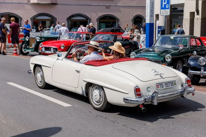 Weißes Cabrio mit Fahrgästen im Ort