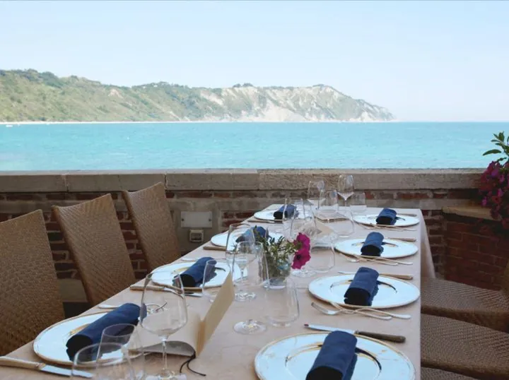 Gedeckte Tafel auf einer Terrasse mit Blick aufs Meer