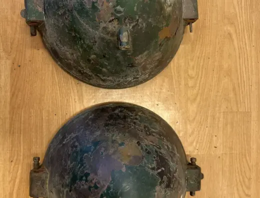Bosch Lkw-Scheinwerfer aus Messing 1920er zu verkaufen, Rückseiten der beiden Messing-Scheinwerfergehäuse mit Haltebügeln, Patina und alten Lackresten, auf Holzuntergrund.
