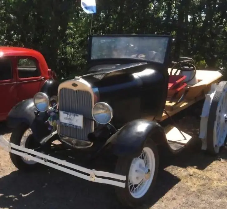 Ford A Baujahr 1927 zu verkaufen, Schwarzer Ford A Roadster von vorne, mit charakteristischem Kühlergrill, runden Scheinwerfern und weißer Stoßstange, geparkt zwischen anderen Oldtimer