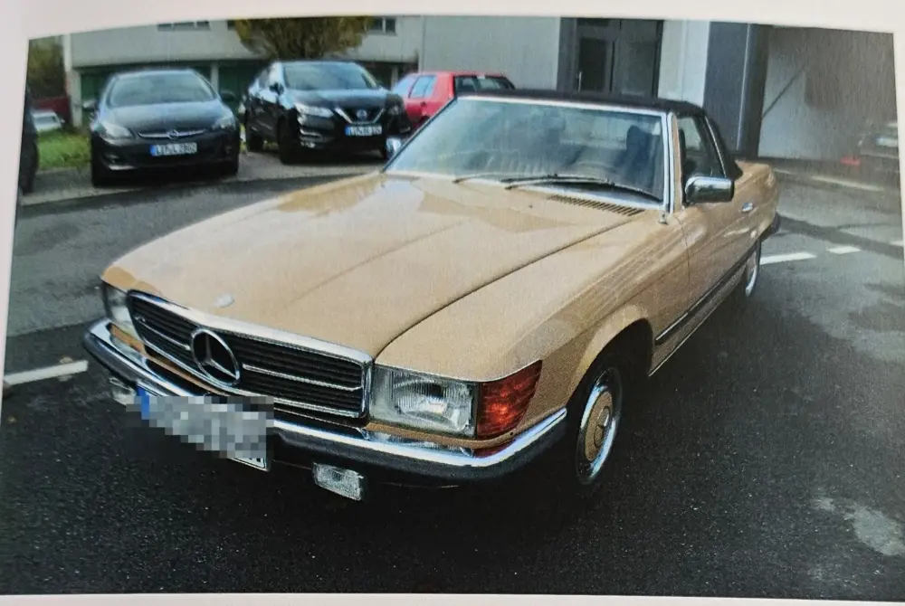Mercedes-Benz 280 SL (R107) zu verkaufen, beiger 280 SL mit geschlossenem schwarzen Verdeck, Frontansicht von links (Gutachtenfoto 11/2023)