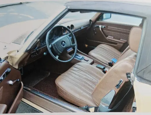 Mercedes-Benz 280 SL (R107) zu verkaufen – Innenraum mit braunen Ledersitzen, Lenkrad und Armaturenbrett, Fahrertür offen (Gutachtenfoto 11/2023)