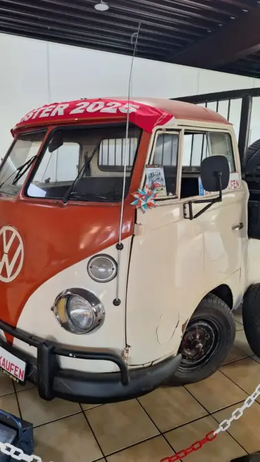 Volkswagen T1 Baujahr 1969 zu verkaufen, Klassischer VW T1 Bulli von 1950er Jahren in zweifarbigem Design (rot/creme) mit aufgemaltem "SURFER 2025" Text auf dem roten Dach, ausgestellt in ein