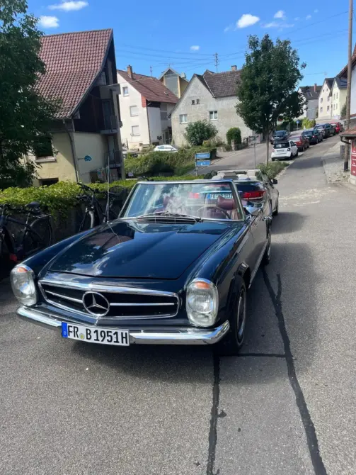 Mercedes Benz Pagode 280 SL Baujahr 1969 zu verkaufen, Blauer Mercedes-Benz Pagode 280 SL Cabrio von vorne auf einer Wohnstraße mit Häusern im Hintergrund.