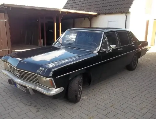 Opel Diplomat Baujahr 1977 zu verkaufen, Schwarzer Opel Diplomat der 1970er Jahre, geparkt auf Pflastersteinen vor einem Carport, glänzende Lackoberfläche und verchromte Zierleisten deutlich