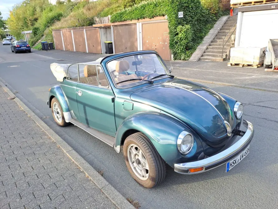 Volkswagen Käfer 1303 LS Cabriolet Baujahr 1976 zu verkaufen, Grünes Volkswagen Käfer 1303 LS Cabriolet von schräg vorne mit geöffnetem Verdeck, geparkt an einer Straße vor Garagen