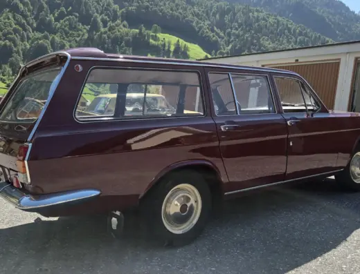 Wolga GAZ 2402 zu verkaufen, Weinroter Wolga GAZ 2402 Kombi von der Seite auf einem Parkplatz vor Bergkulisse