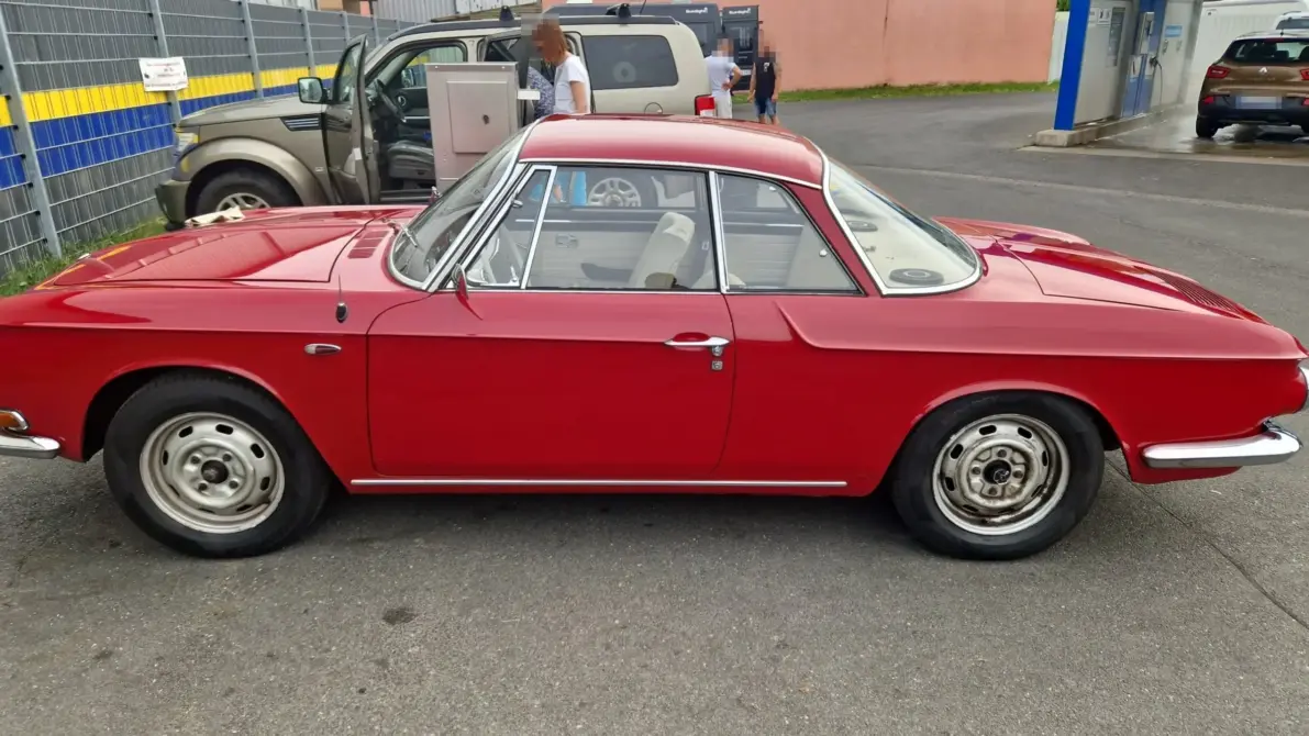Volkswagen Karmann Ghia 1600L T34 Baujahr 1966 zu verkaufen: Roter Volkswagen Karmann Ghia 1600L T34 Coupé, Seitenansicht links auf einem asphaltierten Platz, Stahlfelgen mit Radkappen