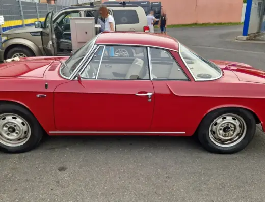 Volkswagen Karmann Ghia 1600L T34 Baujahr 1966 zu verkaufen: Roter Volkswagen Karmann Ghia 1600L T34 Coupé, Seitenansicht links auf einem asphaltierten Platz, Stahlfelgen mit Radkappen