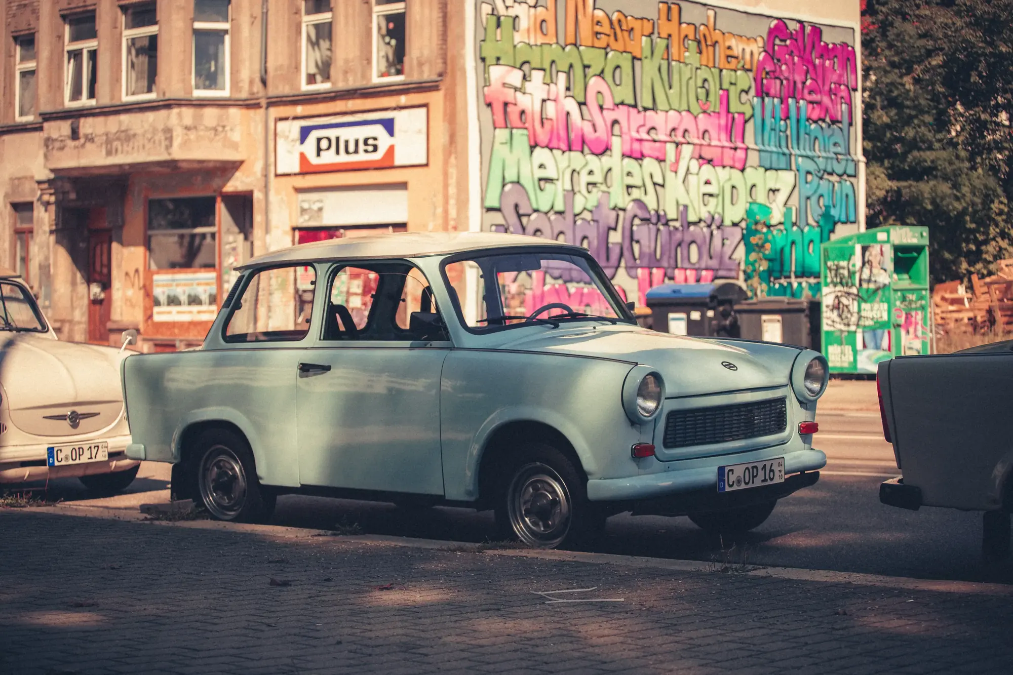 Trabant 601 Limousine Nr.2 1988 mieten in Trabant Vermietung Chemnitz, Rosenpl. 7, 09126 Chemnitz-Bernsdorf, Deutschland (Hellblauer Trabant vor Graffiti)