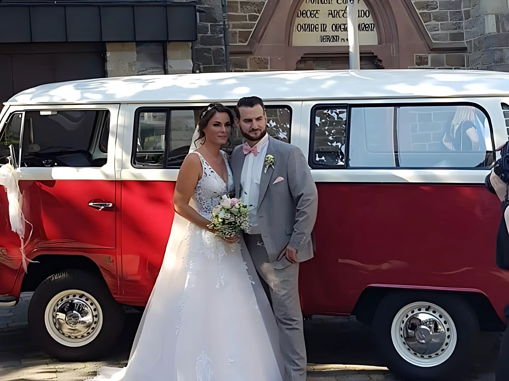 VW T2a, 9 Sitzer 1971 mieten in Bochum (roter/weißer Bus mit Porsche im Hintergrund)