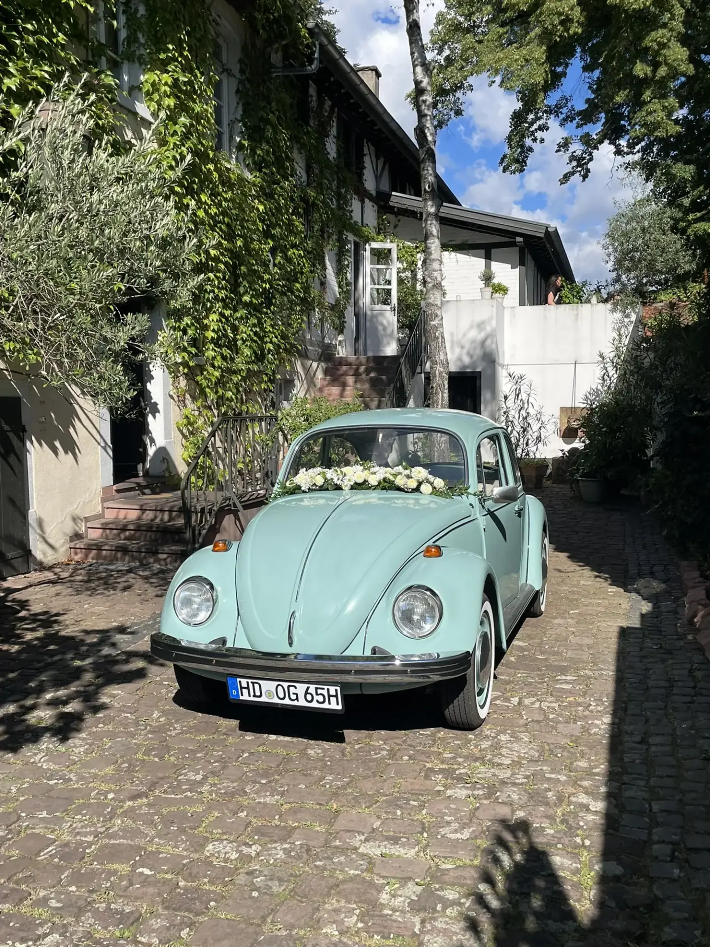 VW Käfer 1200 J 1976 mieten in Hockenheim (Türkiser Käfer mit Blumen)