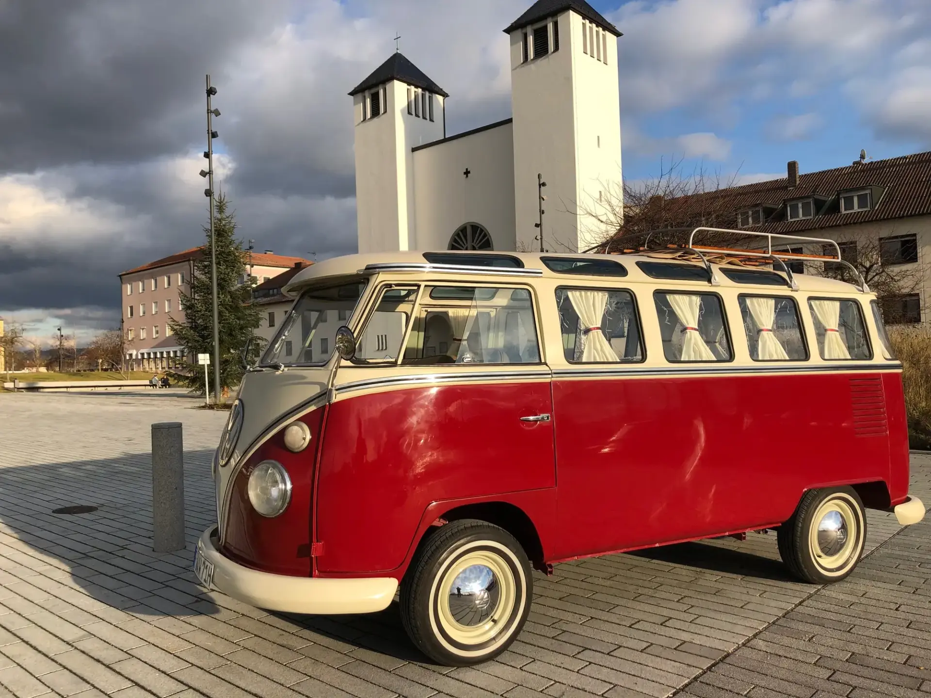 VW Bulli T1 Samba 1971 mieten in Neutraubling (VW Bulli T1 Samba schräg von vorn vor Kirche)